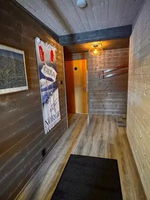 a room with a wooden wall and a hallway at Ustedalen Lodge, Appartement 1 in Geilo