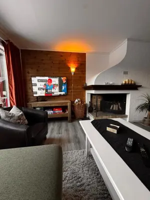 a living room with a fireplace and a tv at Ustedalen Lodge, Appartement 1 in Geilo