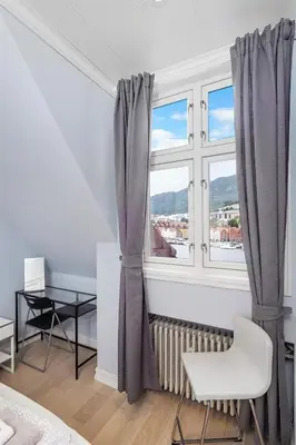 a white room with a window and a table and a chair at Apartment with Beautiful View to Bryggen in Bergen