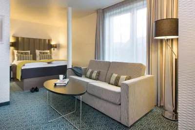 a hotel room with a couch and a bed at Scandic Bakklandet in Trondheim