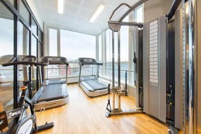 an apartment gym with two treadmills and windows at Scandic Bakklandet in Trondheim