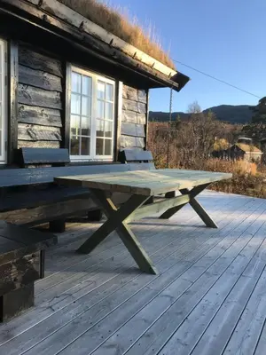 a picnic table on the deck of a cabin at Remestøylflotti Hyttegrend in Hovden