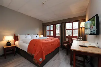 a hotel room with a large bed and a desk at Hunderfossen Hotel & Resort in Hafjell