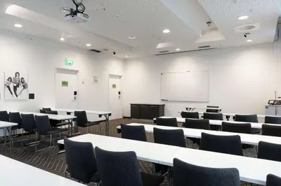 a classroom with tables and chairs and a whiteboard at Scandic Rock City in Namsos