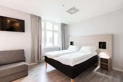 a bedroom with a bed and a couch at Scandic Byparken in Bergen