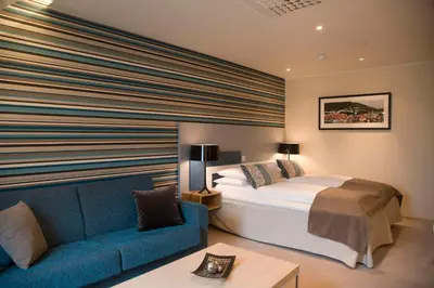 a hotel room with a bed and a blue couch at Scandic Byparken in Bergen