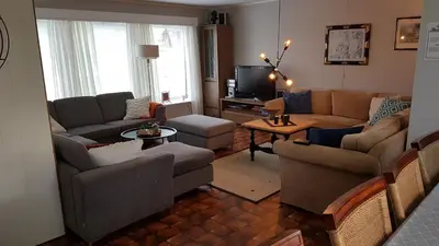a living room with two couches and a tv at Leite Gård near Atlantic Road in Hustadvika in Lyngstad