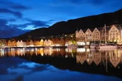 a large building sitting on the water at night at Knudsen Apartment in Bergen