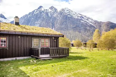 a log cabin with a mountain in the background at Trollstigen Resort in Åndalsnes