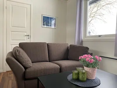 a living room with a couch and a table with flowers at Trollstigen Resort in Åndalsnes