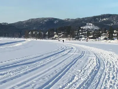 a snow covered beach with people walking in the distance at Bed and Breakfast Hadeland in Harestua