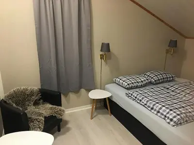 a small bedroom with a bed and a chair at Bed and Breakfast Hadeland in Harestua