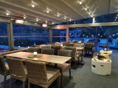 a restaurant with tables and chairs and a large window at Flåm Marina in Flåm