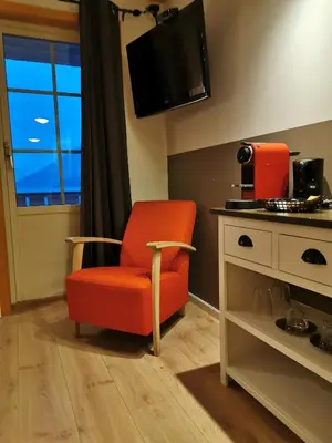 an orange chair sitting in a room with a tv at Flåm Marina in Flåm