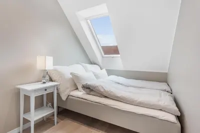 a bed in a room with a window and a table at Fosswinckel Apartments in Bergen