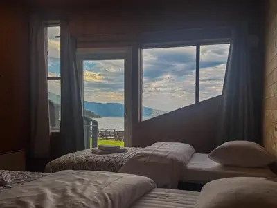 a bedroom with two beds and a large window at Brekkestranda Fjordhotel in Brekke