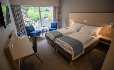 a hotel room with a bed and a balcony at Lærdal Hotel in Lærdalsøyri