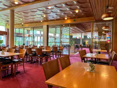 a restaurant with wooden tables and chairs and windows at Lærdal Hotel in Lærdalsøyri