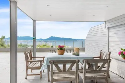 a table and chairs on a patio with a view at Øyjorden Apartment in Bergen