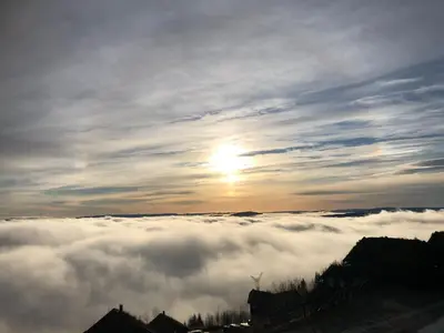 a view of the sun rising above a sea of clouds at Norefjell Panorama in Noresund