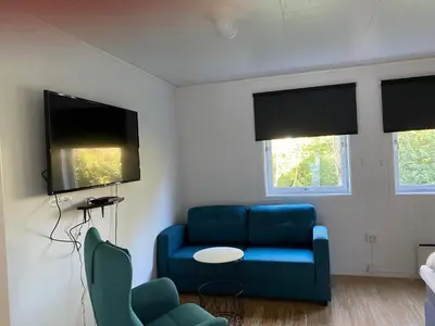 a living room with a blue couch and a table at Fitjar Fjordhotell in Fitjar