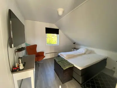 a small room with a bed and a chair at Fitjar Fjordhotell in Fitjar