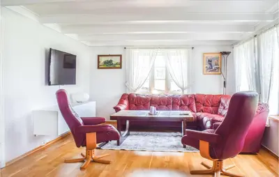a living room with a red couch and two chairs at Lovely Home In Valevåg With Wifi in Valevåg