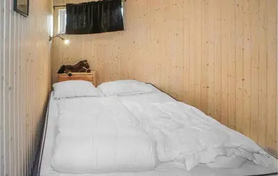 a bed with white sheets and pillows in a room at Lovely Home In Hemsedal With Sauna in Hemsedal
