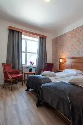 a hotel room with two beds and a window at Oppdal Turisthotell in Oppdal