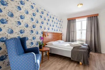 a hotel room with a bed and a chair at Oppdal Turisthotell in Oppdal