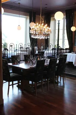 a dining room with a table and chairs and a chandelier at Oppdal Turisthotell in Oppdal