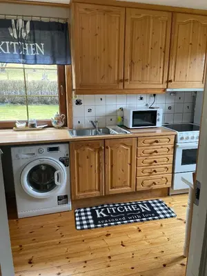 a kitchen with a sink and a washing machine at Apartment AliS in Tønjum