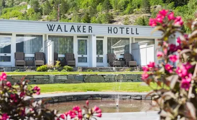 a hotel with a fountain in front of a building at Walaker Hotel in Solvorn
