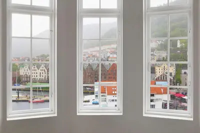 three windows in a room looking out at a city at Scandic Torget Bergen in Bergen