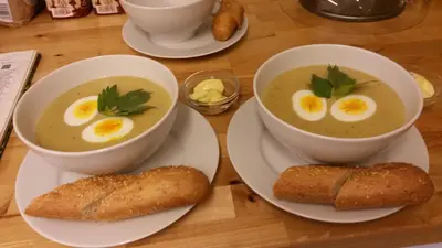 two bowls of soup with eggs and bread on a table at Munkeby Herberge in Levanger