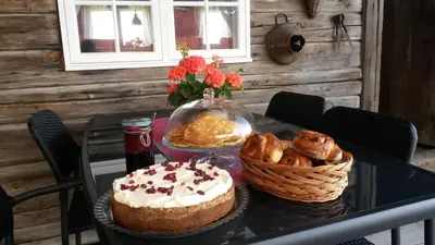 a table with a cake and a basket of pastries at Munkeby Herberge in Levanger