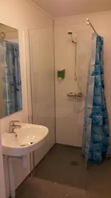 a bathroom with a sink and a shower at Munkeby Herberge in Levanger