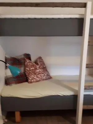a bunk bed with two pillows on the bottom bunk at Munkeby Herberge in Levanger