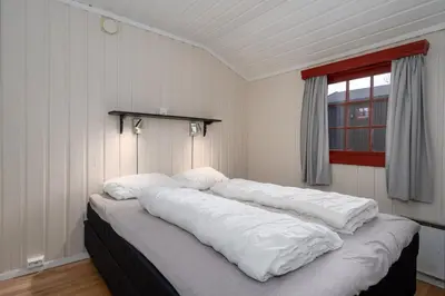 a large bed with white sheets in a room at Knuts Hyttegrend in Beitostøl
