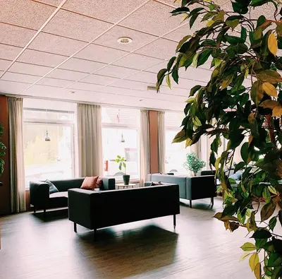 a living room with couches and tables in a building at Rødberg Hotel in Rødberg