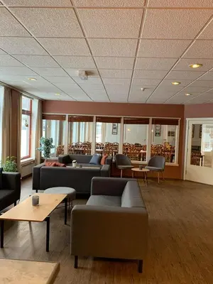 a living room with couches and tables and chairs at Rødberg Hotel in Rødberg