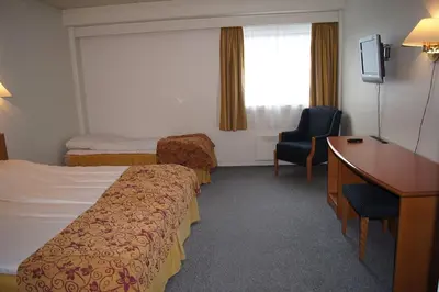 a hotel room with two beds and a desk at Rødberg Hotel in Rødberg