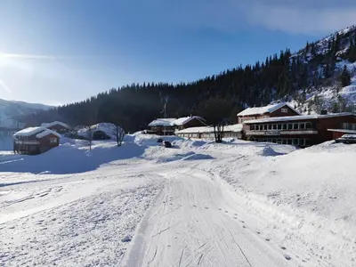 a snow covered road in front of a ski lodge at Grønolen Fjellgard in Beitostøl