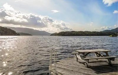 a picnic table on a dock on a lake at Stunning Home In Hebnes With Kitchen in Hebnes