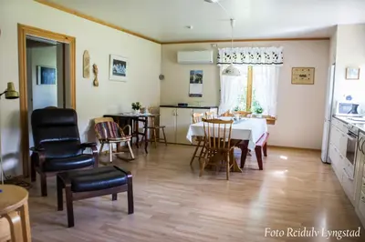 a kitchen and dining room with a table and chairs at Bakken Gårdshus in Rendalen