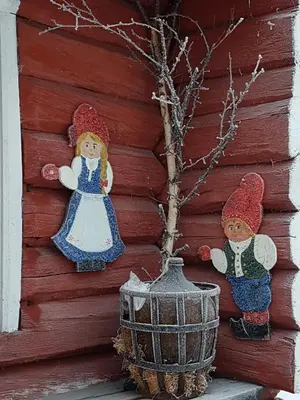 two dolls are on the wall of a house at Bakken Gårdshus in Rendalen