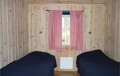 a bedroom with two beds and a window with curtains at Sjusjøen Pihl 185 in Sjusjøen