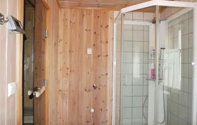 a bathroom with a shower and a wooden wall at Sjusjøen Pihl 185 in Sjusjøen