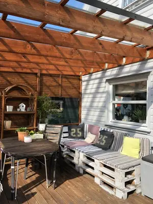 a patio with a wooden pergola and a table and bench at Bed and breakfast in Sauda