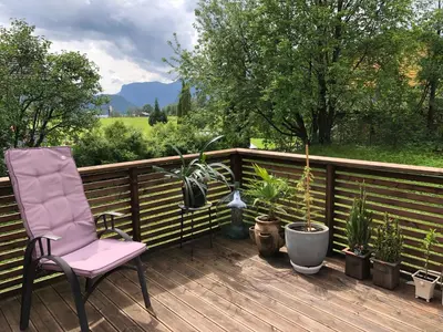 a deck with a chair and potted plants on it at Bed and breakfast in Sauda